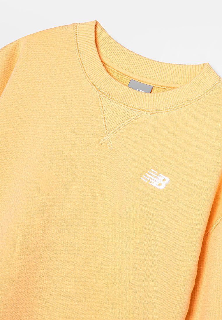 Sudadera amarilla hecha de suave algodón. Presenta un escote redondo, puños de canalé y un logo blanco en el pecho. Textura lisa.