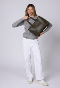 Borsa tote in pelle verde oliva con due manici lunghi, caratterizzata da un dettaglio del logo dorato, texture liscia e design strutturato.