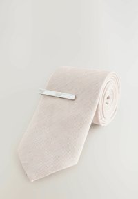 Lyserød slips med herringbone-mønster, rullet med en sølv slipsestrop. Materialet ser tekstureret ud, hvilket tilføjer visuel interesse.