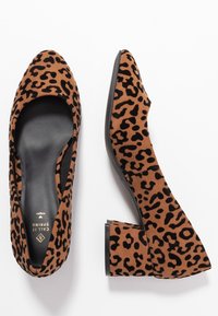 Brown faux suede block-heeled pumps featuring a pointed toe and leopard print pattern. Soft texture with black accents.