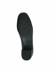 Suela de zapato de goma negra con un patrón de agarre texturizado, que presenta un ligero tacón y la marca "CAPRICE". Tamaño marcado como 37.