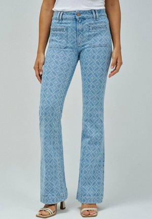 Jean flare bleu clair avec un motif damassé texturé, cinq poches et taille haute. Fini avec une fermeture à bouton et des passants de ceinture.