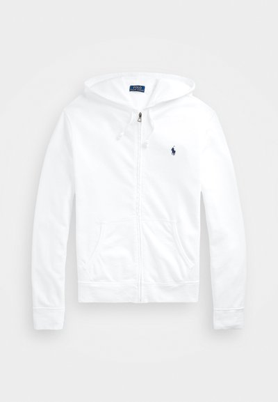 Hvid zip-up hættetrøje lavet af blødt stof, med en dobbelt-laget hætte, forlommer og et lille mørkeblåt logo på venstre bryst.