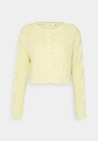 Cardigan giallo tagliato con un motivo a diamante testurizzato, scollatura rotonda e chiusura con bottoni perla. Presenta dettagli intrecciati sulle maniche.