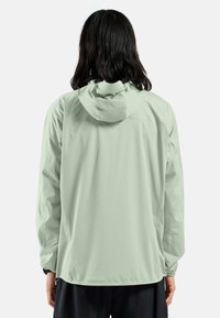 Light green hooded jacket with a smooth, matte finish, long sleeves, and elastic cuffs, featuring a drawstring and subtle logo detail.