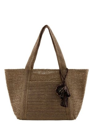 Sac cabas tissé marron avec deux poignées et des pompons décoratifs suspendus à une poignée.