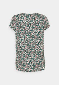 Top negro de manga corta con un patrón floral en blanco, rosa y teal. Tejido ligero con un ajuste relajado y dobladillo curvado.