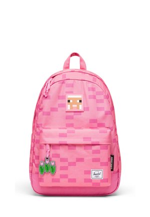 Sac à dos rose avec motif pixellisé, un écusson de mouton Minecraft près du haut et une poche avant avec des breloques tulipes pixellisées.