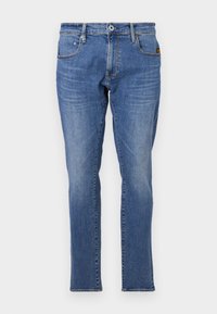 Jeans din denim albastru cu un design clasic cu picior drept, stil cu cinci buzunare și accente cu fire portocalii. Țesătura este texturată și durabilă.