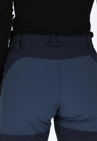 Tummansininen korkeavyötäröinen urheilushortsit, joissa on litteä vyötärö, kontrastinväriset sivupaneelit ja sileä kankaan rakenne.
