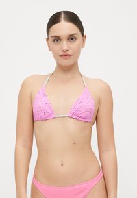 Rozi trokutasti bikini top od teksturiranog materijala s malim ukrasima, podesive trake oko vrata i na leđima, odgovarajuće rozi rebrasti donji dio.