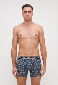 Boxer briefs blu con un motivo festivo di bastoncini di zucchero, fiocchi di neve e rametti di pino. Vita nera con il logo "ONLY & SONS".
