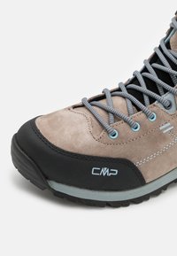 Beige semskete vandresko med sort gummisål, grå snøringer og turkise øjer. CMP-logo på siden. Har forstærket tå og hæl.