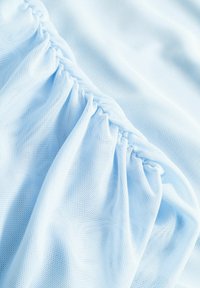 Hellblauer Mesh-Stoff mit gerafften Details, der eine weiche, halbtransparente Textur und ein leichtes Design aufweist, geeignet für Kleidungsstücke.