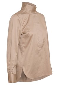 Chemise beige à manches longues avec col montant, deux boutons au niveau du cou, ourlet courbé et patte de boutonnage frontale cachée.