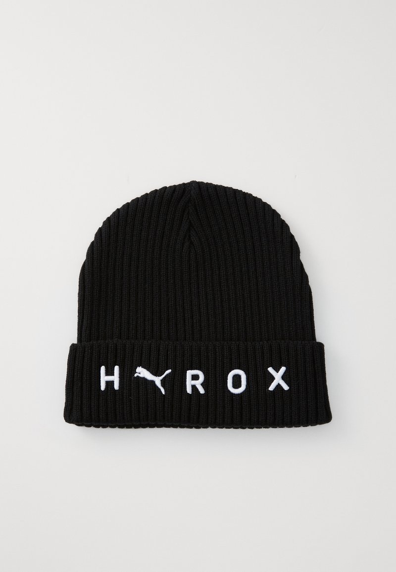 Bonnet en tricot noir avec une texture côtelée. Présente des lettres blanches brodées "HYROX" et un logo Puma sur le revers. 