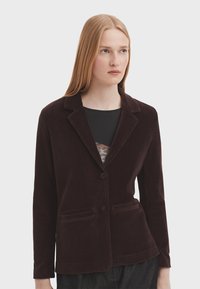 Bordo žametni blejzer s reverom u obliku proreza, dva prednja džepa i dva gumba. Meka tekstura, krojena silueta i dugi rukavi.