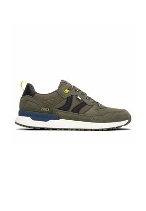Zapatilla baja en verde oliva y negro con suela blanca, ojal amarillo para cordones y "2003" impresa cerca del talón.