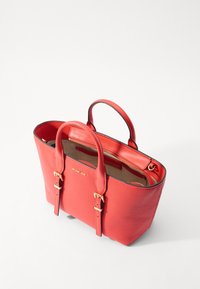 Borsa tote in pelle rossa con texture a ciottoli, doppi manici, dettagli in metallo dorato e una chiusura superiore con zip. Presenta una tasca interna a contrasto.