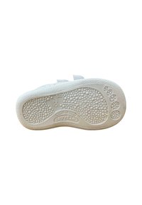 Suela de zapatilla de goma blanca con superficie texturizada y pequeños puntos circulares, etiqueta de la marca "zapyflex" y "HECHO EN ESPAÑA". Talla marcada como 20.