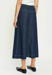 Jeans krilo z širokim, do gležnje dolgem dizajnu, elastičnim pasom, temno modre barve in kontrastnim šivanjem ob robu in šivih.