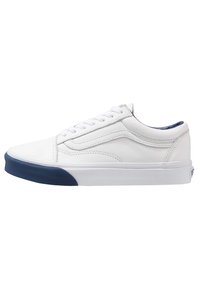 Bílé kožené tenisky s nízkým profilem, vybavené tmavě modrou gumovou podešví, šněrováním a jemnými švy po stranách.