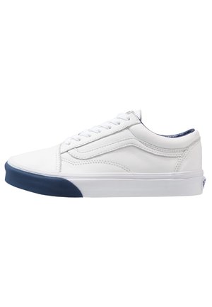 Baskets en cuir blanc à profil bas, avec une semelle en caoutchouc bleu marine, un système de laçage et des détails de couture subtils sur les côtés.