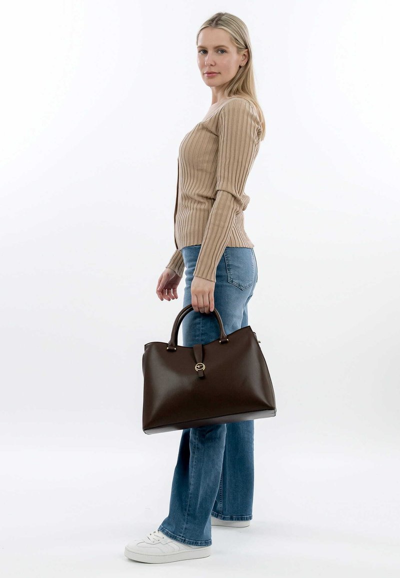 Borsa a tracolla in pelle marrone con forma strutturata, dotata di manico superiore, accento hardware circolare e superficie liscia.