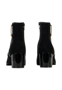 Bottes chelsea en daim noir avec bout arrondi, talon bloc noir brillant, fermeture éclair latérale et détail accent doré sur la tirette de la fermeture éclair.