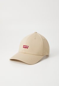 Beige baseballpet van katoen met een gebogen klep, met een rood Levi's logo patch op de voorkant.