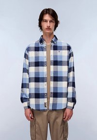 Button-up shirt with a blue and white check pattern, long sleeves, fabric texture, a small logo on the chest, paired with beige cargo pants.