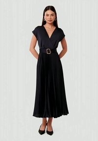Abito midi plissettato nero con design a portafoglio, maniche corte, una cintura larga con fibbia dorata e una texture liscia.