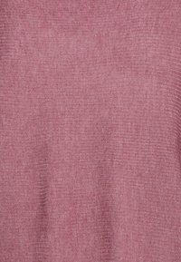 Stickad pullover i mjuk rosa kvalitet, med en strukturerad ribbad modell och en slät, lätt känsla. Inga synliga sömmar eller dekorationer.