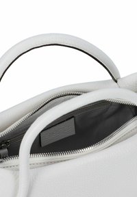 Borsa a mano in pelle bianca con finitura testurizzata, manici superiori e chiusura zip con hardware argento. L'interno è in tessuto grigio con una tasca.