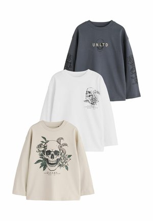 Tre langærmede skjorter med kranie- og blomsterdesign, i grå med "UNLTD," hvid og beige farver, vist på en hvid baggrund.