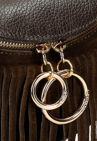 Piccola borsa in pelle marrone con un design in frange di suede, dotata di accessori in oro e doppie famose circolari vicino alla chiusura con cerniera.