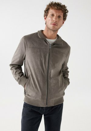 Grijze leren bomberjack met een gladde textuur, geribbelde kraag en manchetten, ritsluiting aan de voorkant en zijzakken, gecombineerd met donkere jeans.