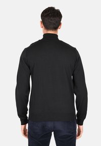 Pullover nero a maniche lunghe con colletto alto, polsini e orlo a costine. Texture liscia, design aderente e senza motivi o dettagli visibili.