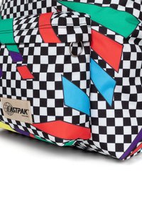 Black and white checkered backpack with colorful geometric shapes in red, green, blue, and purple. Features a side pocket with a metal ring.