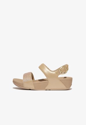 Beige sandalen met een glanzende leren afwerking en een gestructureerde band met steenjes. Verstelbare enkelsluiting en gevormde zool.