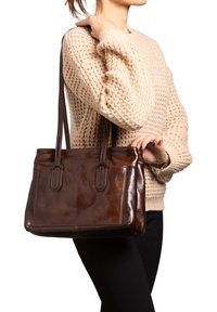 Borsa tote in pelle marrone con doppio manico, texture liscia, forma rettangolare, dotata di una tasca frontale e una sottile lucentezza.