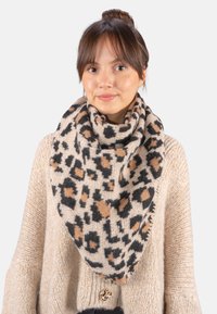 Écharpe en imprimé léopard en tissu doux, présentant des nuances de beige, noir et marron. Tissage texturé avec un design cosy et oversize.