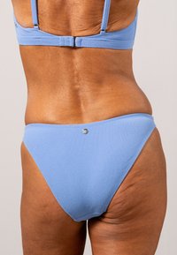 Ljusblå bikiniunderdel med en slät yta, låg midja och en liten silveraccentdetalj bak.