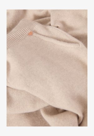 Beige gestrickter Pullover aus weichem Material. Verfügt über einen gemusterten Rippkragen und ein kleines, rundes Logo-Detail near der Schulter.