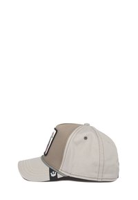 Gorra de béisbol en tela bicolor beige y gris. Presenta un parche frontal con bordado detallado y costura en contraste a lo largo del borde.