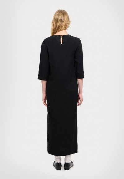 Black maxi dress with three-quarter sleeves, keyhole back detail, and a smooth texture. Floor-length design creates a simple silhouette.