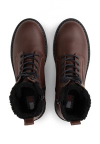 Botas de piel marrón hasta el tobillo con cordones negros, forro de piel sintética, punta redonda y suela de goma resistente; cuentan con cremalleras laterales para facilitar el uso.