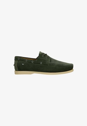 Grüne Wildlederschuhe im Bootsstil mit einem lässigen Design, ausgestattet mit Metallösen, einer abgerundeten Spitze und einer kontrastierenden hellen Gummisohle.
