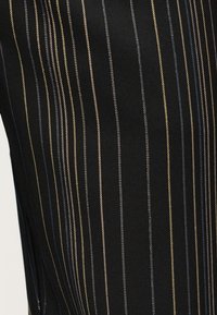 Μαύρο ύφασμα με κάθετες λεπτές μπεζ και μπλε ρίγες σε διάφορα πλάτη.