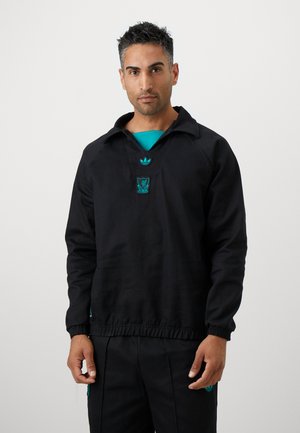 Black pullover with a relaxed fit, featuring a collar and an elastic waistband. Decorated with turquoise Adidas logo and Liverpool crest.